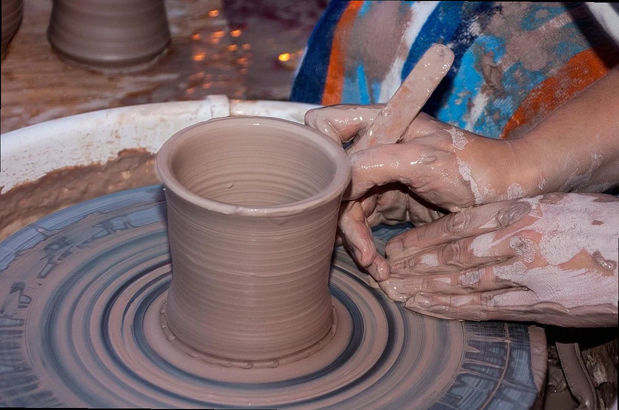Potier travaillant l'argile sur un tour, façonnant un pot à la main avec habileté et créativité